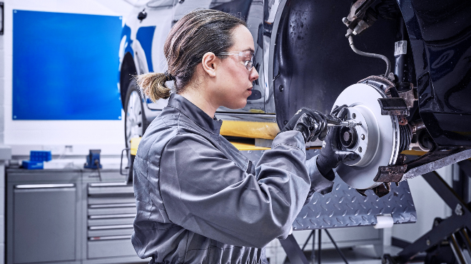 Delphi Technologies Expert replacing the front disks and brake pads of a raised vehicle.